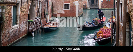 Typischen Kanal Szene in Venedig, Italien, mit Gondeln. und Gondoliere rudern Touristen in die Stadt. Stockfoto