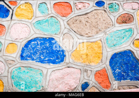 Hintergrund der natürlichen Steine, zusammen mit Zement befestigt und mit bunten Farben bemalt. Stockfoto