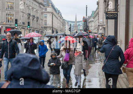 Einkäufer bei nassem Wetter in einer belebten Einkaufsstraße Stockfoto