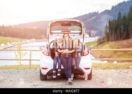 Familie, die mit dem Auto anreisen und Spaß Umarmen im Kofferraum Stockfoto