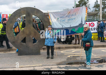 Aldermaston, UK. 1 Apr, 2018. CND errichtet seinen riesigen CND-Symbol Installation am Haupteingang der AWE Aldermaston der 60. Jahrestag der ersten Aldermaston März Tausende gegen die Bombe und geformte radikalen Protest für Generationen mobilisiert zu feiern. Ihr Protest außerhalb der Atomic Weapons Establishment ein Riese, iconic Symbol des Friedens, Reden, unter anderem durch einige von denen auf der ursprünglichen März enthalten, singen und trommeln und feierten den UN-Vertrag über das Verbot von Atomwaffen. Credit: Peter Marschall/Alamy leben Nachrichten Stockfoto