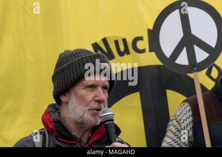 Aldermaston, UK. 1 Apr, 2018. CND Stuhl Dave Webb spricht als CND der 60. Jahrestag der ersten Aldermaston März Tausende gegen die Bombe und geformte radikalen Protest für Generationen mobilisiert feiert. Ihr Protest außerhalb der Atomic Weapons Establishment ein Riese, iconic Symbol des Friedens, Reden, unter anderem durch einige von denen auf der ursprünglichen März enthalten, singen und trommeln und feierten den UN-Vertrag über das Verbot von Atomwaffen. Kampagne Atomwaffen abzuschaffen. Credit: Peter Marschall/Alamy leben Nachrichten Stockfoto