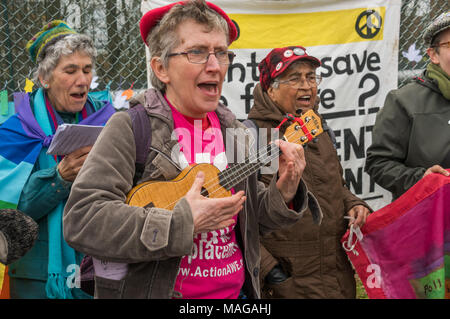 Aldermaston, UK. 1 Apr, 2018. Welsh sozialistischen Chor Côr Cochion singt, begleitet von einem ukelele als CND der 60. Jahrestag der ersten Aldermaston März Tausende gegen die Bombe und geformte radikalen Protest für Generationen mobilisiert feiert. Ihr Protest außerhalb der Atomic Weapons Establishment ein Riese, iconic Symbol des Friedens, Reden, unter anderem durch einige von denen auf der ursprünglichen März enthalten, singen und trommeln und feierten den UN-Vertrag über das Verbot von Atomwaffen. Credit: Peter Marschall/Alamy leben Nachrichten Stockfoto