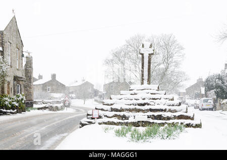 Carperby, North Yorkshire, England. 2. April 2018. UK Wetter: Dorf Kreuz in Wensleydale mit Schnee am Ostermontag © Andrew Fletcher/Alamy Leben Nachrichten abgedeckt Stockfoto