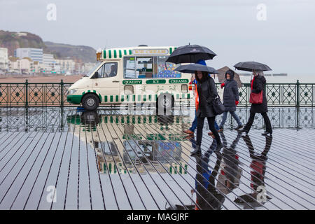 Hastings, East Sussex, UK. 2 Apr, 2018. Bank Holiday UK Wetter: Duschen, regnerisch Regen in der Küstenstadt Hastings dieses Ostern Montag Nachmittag mit vielen Menschen und über selbst Abschirmung mit Sonnenschirmen. © Paul Lawrenson 2018, Foto: Paul Lawrenson/Alamy leben Nachrichten Stockfoto