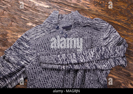 Die Warm Grey Melange Männer winter Pullover auf einer hölzernen Hintergrund Stockfoto