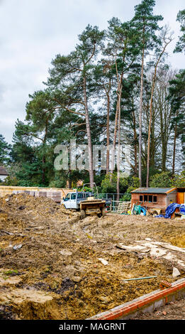 Dumper und weißen Van auf einem Schlammigen aufgewühlten bis Wohnungsbau Website in Surrey im Südosten Englands in feuchten, schlechtes Wetter Stockfoto