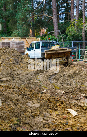 Dumper und weißen Van auf einem Schlammigen aufgewühlten bis Wohnungsbau Website in Surrey im Südosten Englands nach nassen, schlechtes Wetter Stockfoto