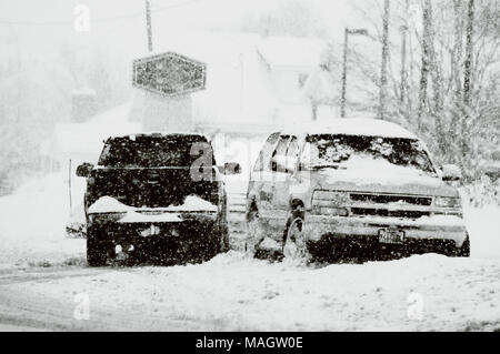 Zwei Fahrzeuge im Schnee stecken, während um sie herum die Schneeflocken fallen. Stockfoto