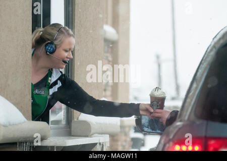 Eine Telefonzentrale austeilen einen Kaffee im Starbucks im Schnee. Stockfoto