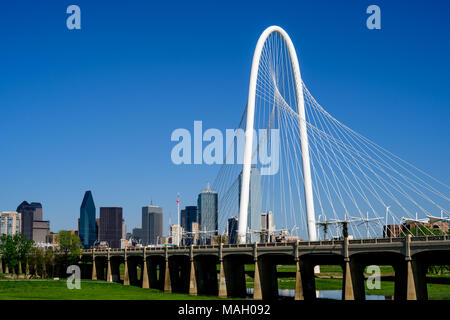 Dallas, Texas Skyline mit Margaret Hunt Hill Brücke im Vordergrund zusammen mit dem Ronald Kirk Fußgängerbrücke. Strahlend blauer Himmel Hintergrund. Stockfoto