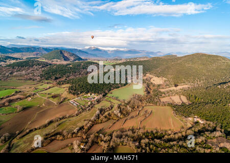 Heißluftballon fliegen mit croscat öffnen Vulkan und Bergen im Hintergrund, bewölkter Tag, Olot, Katalonien, Spanien Stockfoto