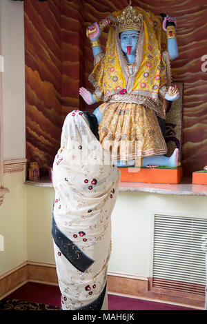 Ein Hindu Anbeter Gebet & Meditation vor einer Statue der Göttin Kali in der tulsi-Tempel in South Richmond Hill, Queens, New York. Stockfoto