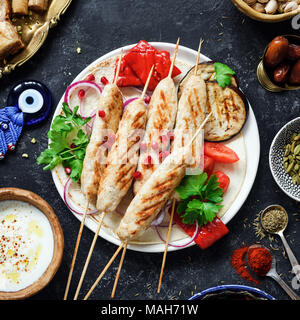 Chicken Kebab, Tavuk sish Kebab mit Petersilie, gegrillte Auberginen, Paprika und Joghurt Sauce auf dunklem Hintergrund. Ansicht von oben, Quadrat Erntegut Stockfoto