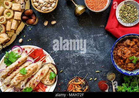 Türkische oder arabische Küche. Türkische Lebensmittel auf dunklem Stein, Ansicht von oben mit der Kopie Platz für Text. Kebap, Baklava, Imam bayildi, Gewürze und Nüsse Stockfoto