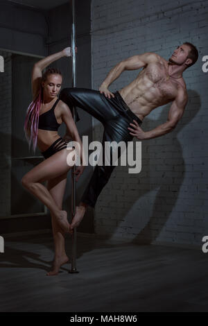 Mann und eine Frau, die an einer Stange tanzen unter Beweis stellt. Stockfoto