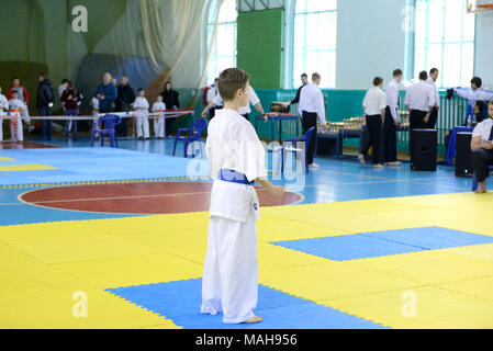 Wettbewerb unter Kindern in Karate, Kata. EIN 10-11 jähriger Junge steht auf der Matte, im fudo dachi er bereit ist, in Kata, Karate kyokushi Stockfoto