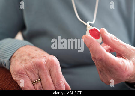 Nahaufnahme von Unwohl Senior Woman Holding Personal Alarm-Taste zu Hause Stockfoto