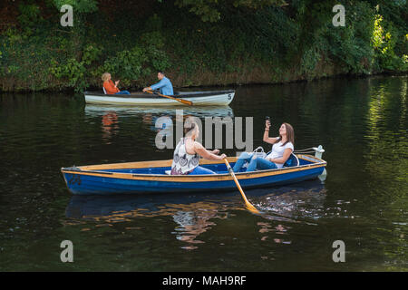 4 Personen fahren, entspannend & Spaß in 2 Ruderboote (1 junge Frau im Boot ist unter selfie) - Flusses Nidd im Sommer, Knaresborough, England, UK. Stockfoto