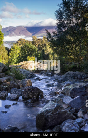 Anfang Herbst an Ashness Brücke mit Skiddaw Berg im Hintergrund. In der Nähe von Derwentwater, Lake District, Cumbria, England, Großbritannien Stockfoto