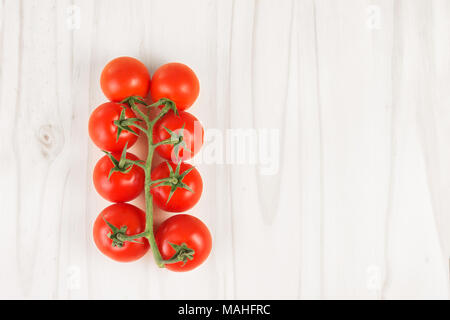 Rote Tomaten auf der Rebe auf einem weißen Holz Oberfläche Reif. Ansicht von oben. Platz kopieren Stockfoto