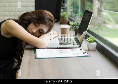 Business woman müde schlief auf dem Schreibtisch, vor ihrem Laptop. Stockfoto