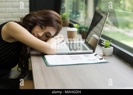 Business woman müde schlief auf dem Schreibtisch, vor ihrem Laptop. Stockfoto