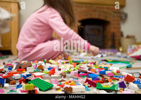 Kind saß auf dem Boden spielen mit Lego Stockfoto