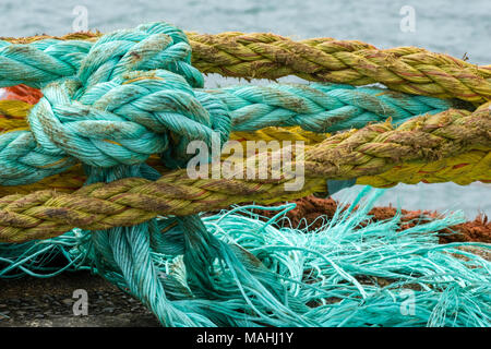 Alter Mann mit Seilen oder Kunststoff und Nylon Seile für die Schifffahrt und die Fischerei auf Trawlern und von Fischern genutzt. Kunststoff Umweltverschmutzung und verworfen Seil Stockfoto