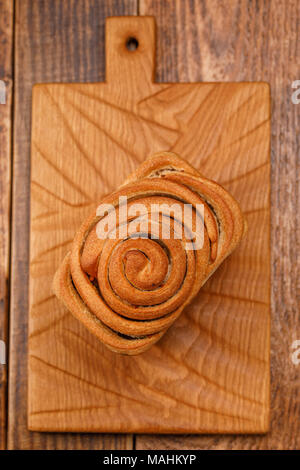 Schöne hausgemachte Brot auf einem Holzbrett. Eine schöne Kombination aus der Farbe eines Holz- Hintergrund und Brot. Stockfoto