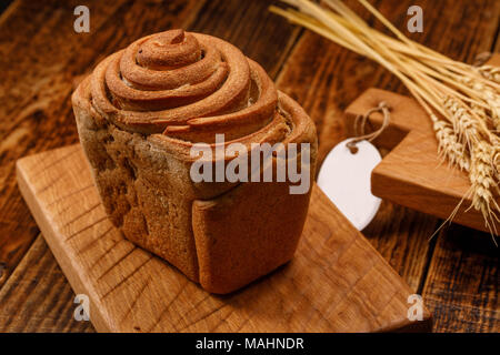 Schöne hausgemachte Brot auf einem Holzbrett. Eine schöne Kombination aus der Farbe eines Holz- Hintergrund und Brot. Knoblauch Brot durch eigene h Stockfoto