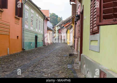 Kopfsteinpflaster, enge und bunten Straßen Wind bis zu der Zitadelle in der Altstadt von Schäßburg, Siebenbürgen, Rumänien. Stockfoto