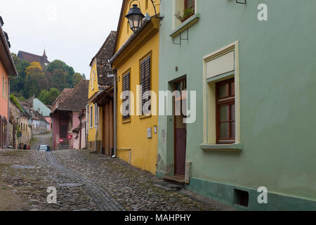 Kopfsteinpflaster, enge und bunten Straßen Wind bis zu der Zitadelle in der Altstadt von Schäßburg, Siebenbürgen, Rumänien. Stockfoto