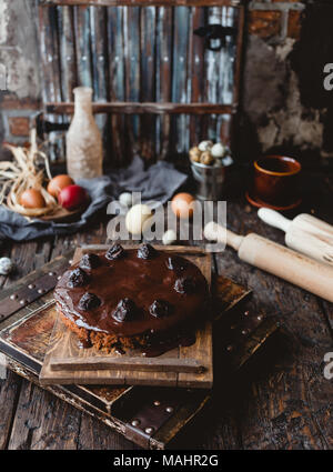 Ostern bunte Eier und Schokoladenkuchen auf rustikalen Holztisch Stockfoto
