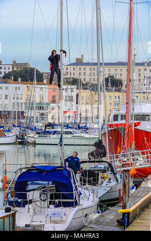 Mann auf der Hälfte ein Boot mast Reparaturen Stockfoto