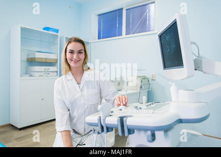 Lächelnde Arzt, Ultraschall. Der Arzt durchgeführt eine Ultraschalluntersuchung. Stockfoto