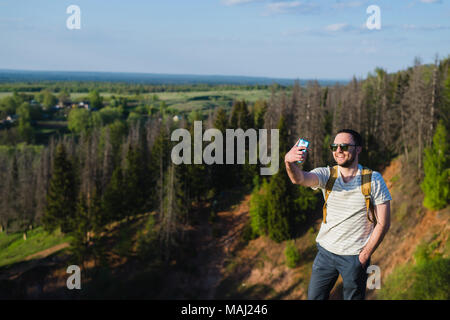 Stilvolle Jüngling mit einem Bart Sonnenbrille macht Selfie auf der Canyon-Klippe Stockfoto