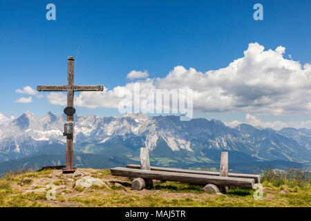 Weiten Panoramablick auf die Landschaft vom Gipfel des Berges Gasselhoehe mit Kreuz und Holzbank zu Berge Dachstein in der Steiermark, Österreich Stockfoto