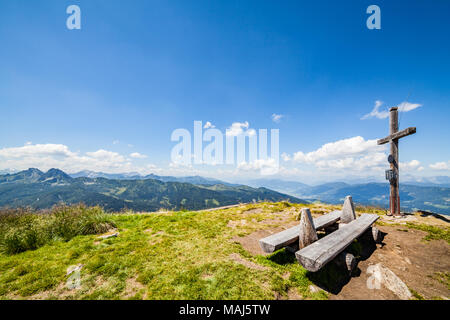 Weiten Panoramablick auf die Landschaft vom Gipfel des Berges Gasselhoehe mit Kreuz und Holzbank zu Berge Dachstein in der Steiermark, Österreich Stockfoto