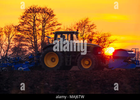 Die untergehende Sonne hinter den Traktor in die Felder in der Nähe von Garstang, Lancashire, England Stockfoto