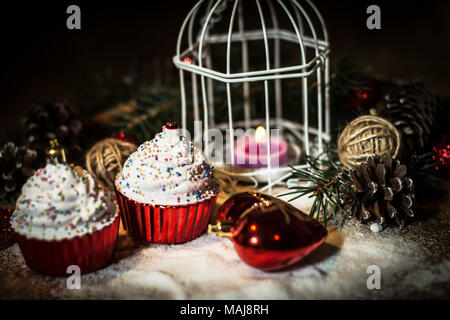 Cupcakes, Weihnachten Kerze und Weihnachtsschmuck auf Holz- ba Stockfoto