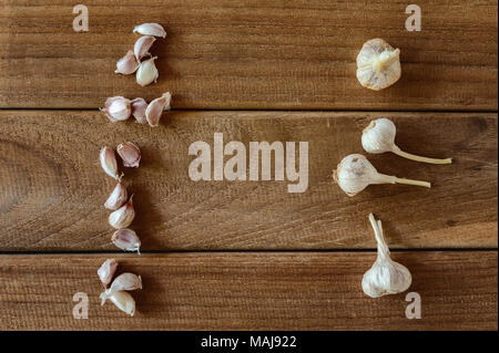 Knoblauchzehen und Knoblauch Zwiebel auf Holz vintage Hintergrund. Stockfoto