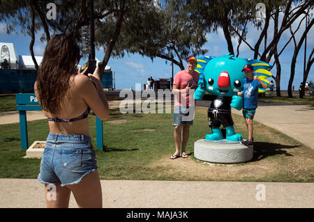 Strand goers Spaziergang durch eine Statue des Commonwealth Games Maskottchen Borobi die blaue Koala vor den Commonwealth Games 2018 in der Gold Coast, Australien. Stockfoto