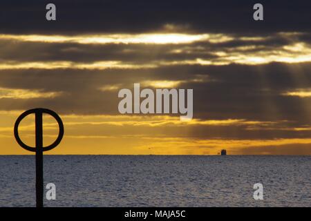 Firery Sonnenaufgang über der Nordsee in einer ruhigen Morgen, Strand Groyne im Vordergrund. Strand von Aberdeen, Schottland, Großbritannien. März 2018. Stockfoto
