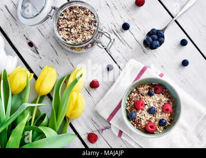 Getreide in einer Schüssel, Frühstück mit frischen Früchten und Müsli, das gesunde Essen. Frühstück Schüssel auf einem Holztisch, rustikalen Szene. Stockfoto