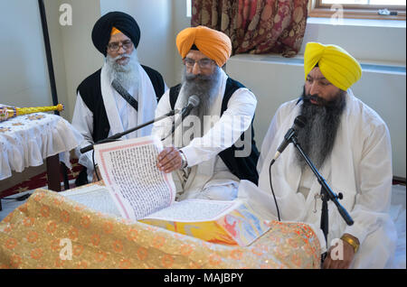 Sikh Priester, Granthis, lesen Sri Guru Granth Sahib, dem heiligen Buch der Sikhs. In Richmond Hill in Queens, New York. Stockfoto