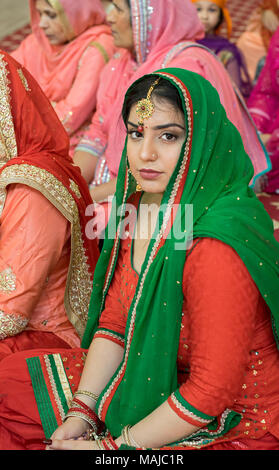 Stellen Portrait von eine wunderschöne Hochzeit Gast im Tempel an der Gurdwara Sikh Kulturellen Gesellschaft in Richmond Hill, Queens, New York City sitzt. Stockfoto