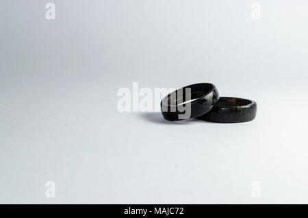 Paar coconut Ringe zusammen auf einem weißen Hintergrund. Intensive schwarze Ton. Handwerk in nordöstlich der Brasilianischen indigenen Ring. Tucum Ring. Stockfoto