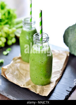 Grüne Smoothie in Gläser. Fitness oder Diät Drink mit Kiwi, Brokkoli, Salat und verschiedenen Zutaten. Gesundes Getränk in einer Glasflasche. Stockfoto