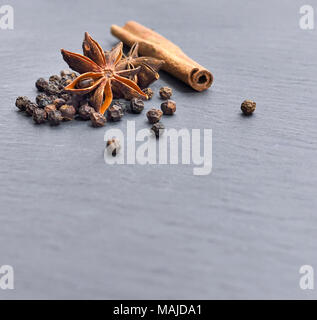 Weihnachten Gewürze auf einem schwarzen Hintergrund. Weihnachten, Advent Backen mit getrockneten Sternanis, Zimt, Pfeffer. Stockfoto